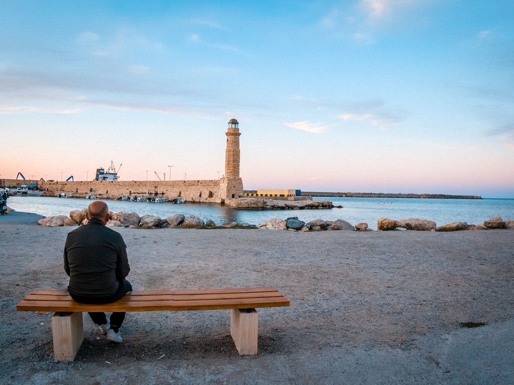 Rethymno i oktober man sitter på en bänk vid havet