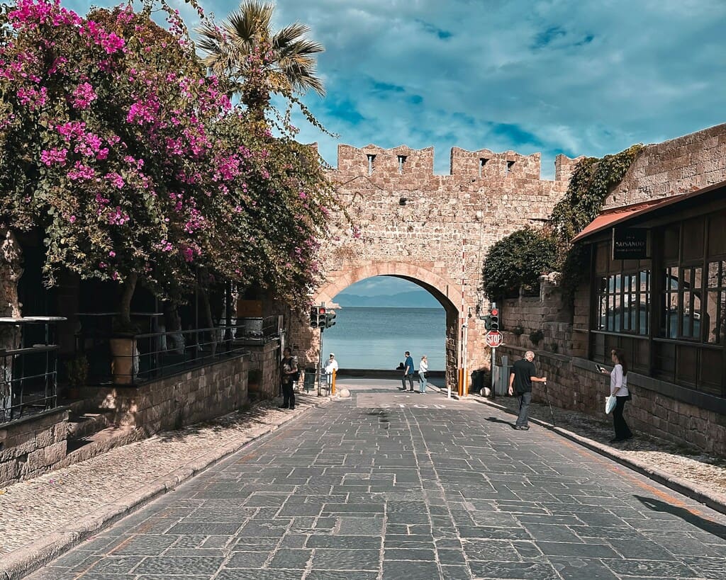 a-cobblestone-street-with-a-stone-arch-leading-to-the-ocean (rue Cobblestone avec une arche en pierre menant à l'océan)